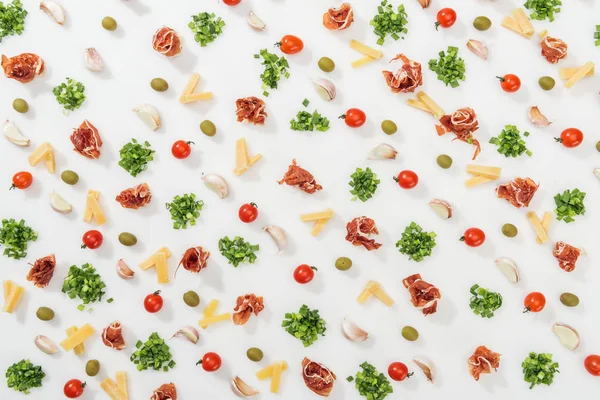 Top view of olives, garlic cloves, greenery, prosciutto, cut cheese and cherry tomatoes — Stock Photo