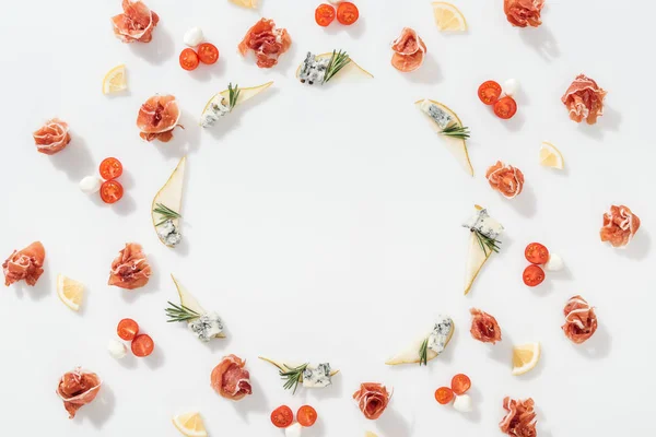 Flat lay of sliced pears with blue cheese and rosemary twigs near prosciutto, and healthy ingredients on white background — Stock Photo