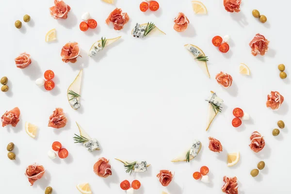 Flat lay of sliced pears with blue cheese and rosemary twigs near prosciutto, and organic ingredients on white background — Stock Photo