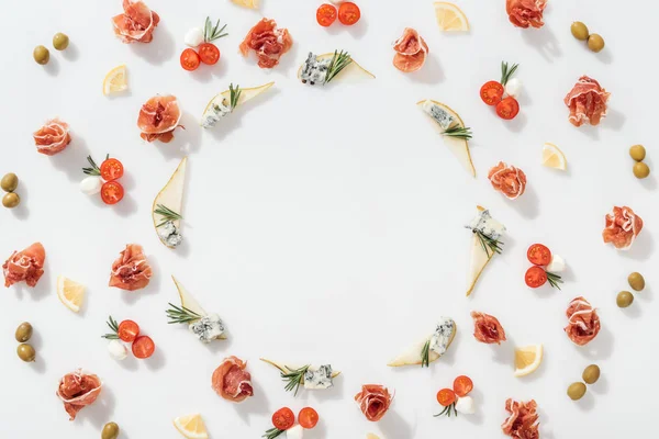 Top view of sliced pears with blue cheese and rosemary twigs near prosciutto, and organic ingredients on white background — Stock Photo