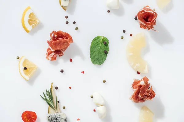 Flat lay of delicious prosciutto near organic ingredients and spices on white background — Stock Photo