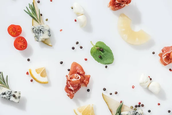 Flat lay of sliced pears with blue cheese near tasty prosciutto and organic ingredients and spices on white background — Stock Photo