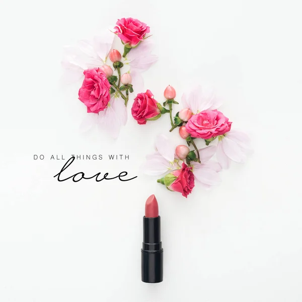 Vista superior de la composición con rosas, brotes y pétalos con lápiz labial sobre fondo blanco con hacer todas las cosas con letras de amor - foto de stock