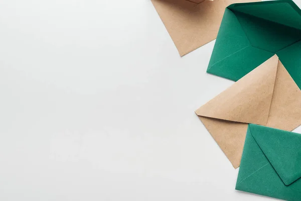 Top view of brown and green envelopes on grey background — Stock Photo