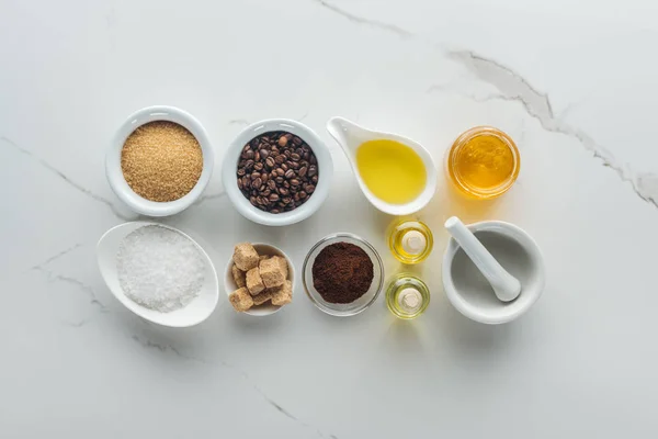 Top view of different ingredients for homemade cosmetics, and pounder on white surface — Stock Photo