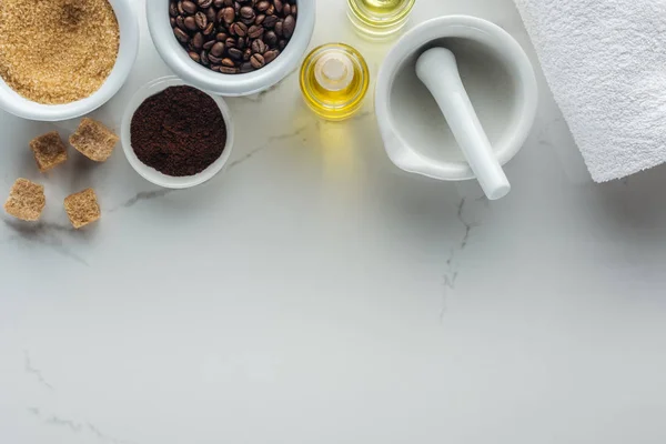 Vista superior de pounder e diferentes ingredientes naturais em tigelas e garrafas na superfície branca — Fotografia de Stock