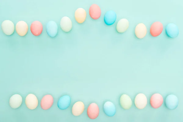 Vista superior de huevos de Pascua pastel aislados en azul - foto de stock