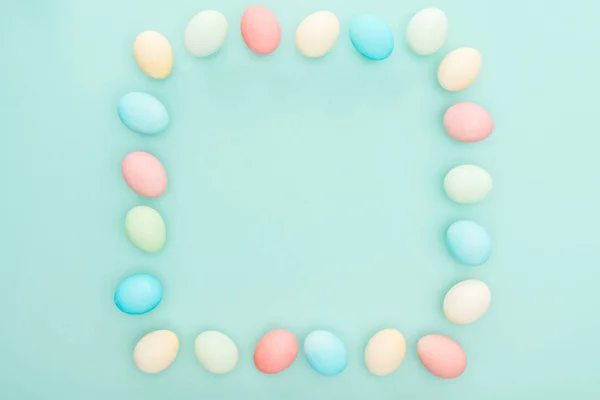 Vue du dessus du cadre vide en œufs de Pâques pastel isolés sur bleu — Photo de stock