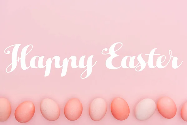 Щасливий Великодній лист з традиційними розфарбованими яйцями в ряд ізольовані на рожевому — стокове фото