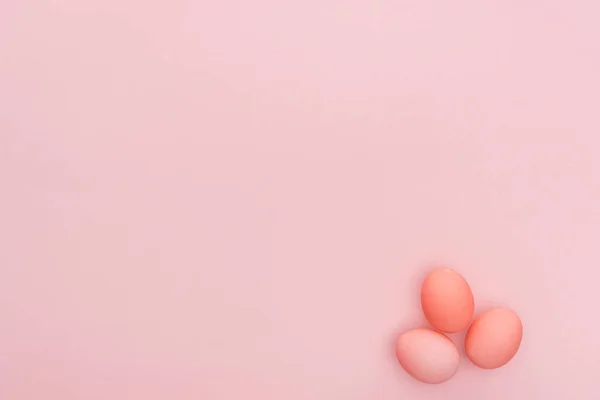 Верхний вид трех пасхальных яиц, выделенных розовым цветом с копировальным пространством — стоковое фото