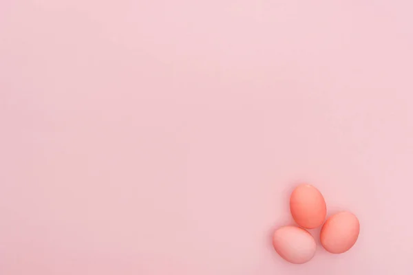 Vue de dessus de trois œufs de Pâques pastel isolés sur rose avec espace de copie — Photo de stock