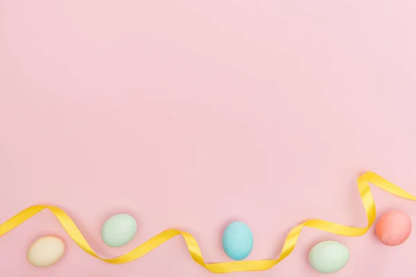 Top view of ribbon and pastel easter eggs isolated on pink — Stock Photo