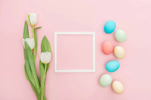 Top view of tulip flowers and easter eggs with frame isolated on pink — Stock Photo