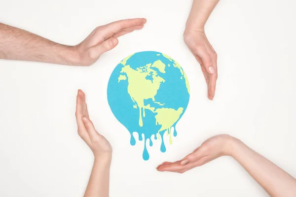 Paper cut melting earth surrounded by male and female hands on white background, global warming concept — Stock Photo