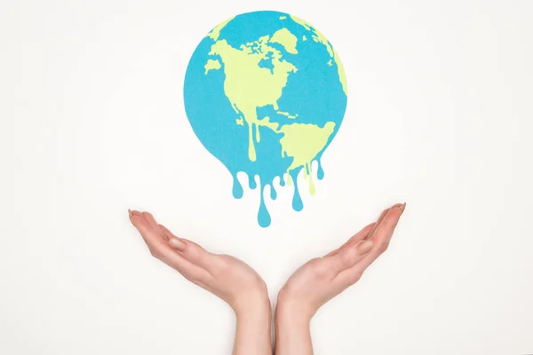 Cropped view of woman holding open hands under paper cut melting globe on white background, global warming concept — Stock Photo