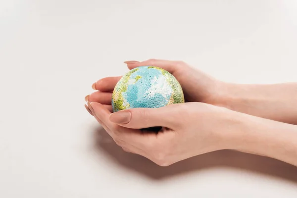 Cropped view of female hands with globe model on white background, global warming concept — Stock Photo