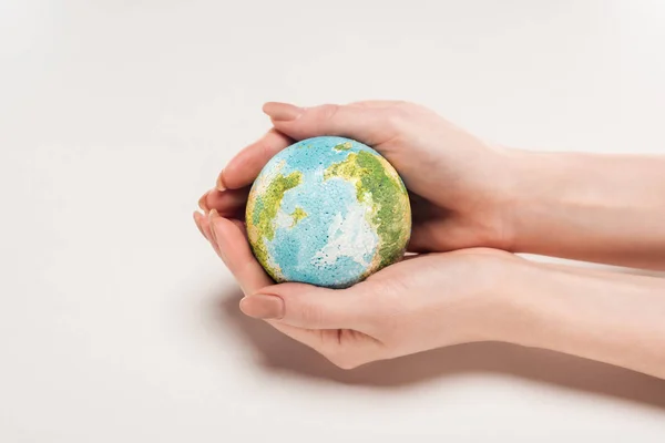 Cropped view of woman holding earth model on white background, global warming concept — Stock Photo