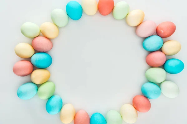 Vue de dessus des œufs de Pâques pastel comme cadre circulaire isolé sur gris — Photo de stock