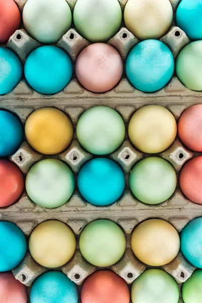 Вид зверху на традиційні барвисті великодні яйця в паперовій тарі — Stock Photo