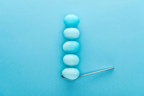Top view of blue easter eggs on spoon isolated on blue — Stock Photo