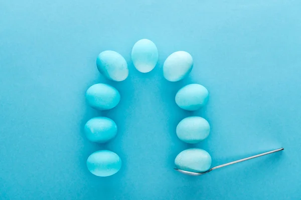 Top view of easter eggs on spoon isolated on blue — Stock Photo