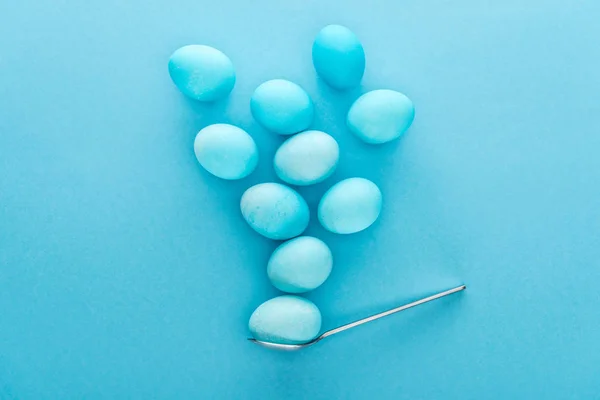 Top view of traditional easter eggs on spoon isolated on blue — Stock Photo