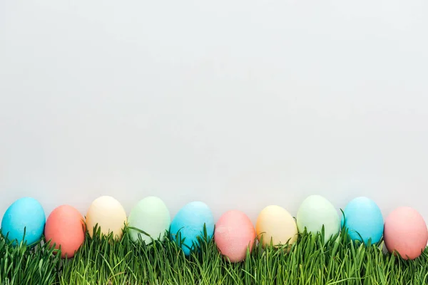Vista superior de los huevos tradicionales de Pascua sobre hierba aislada sobre gris - foto de stock