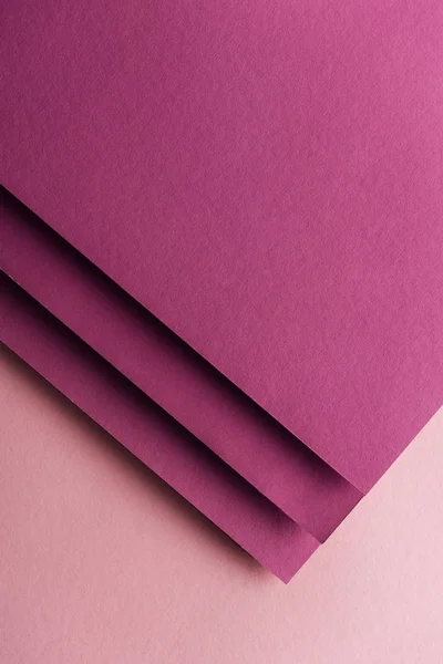 Top view of blank and colorful burgundy sheets of paper on pink background with copy space — Stock Photo