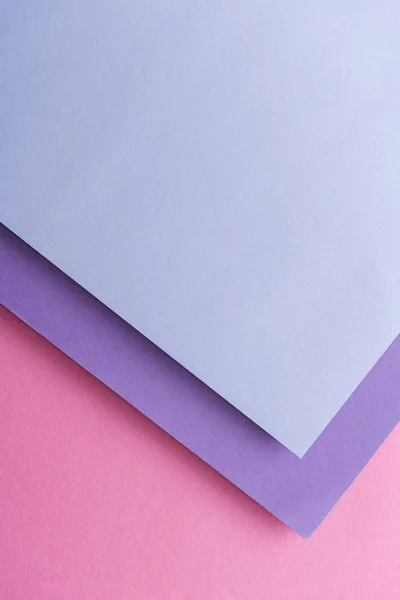 Vista dall'alto di fogli di carta blu e viola su sfondo rosa con spazio per la copia — Foto stock