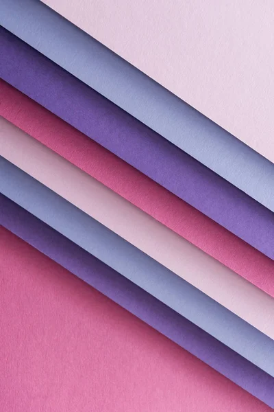 Empty blue, white, pink and purple sheets of paper on pink background — Stock Photo