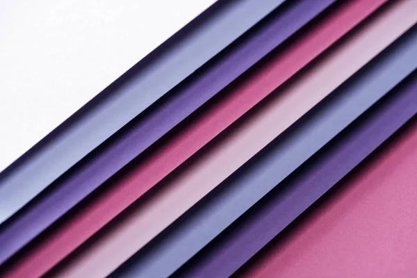 Blue, white, pink and purple papers on pink background — Stock Photo