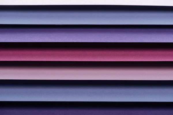 Hojas de papel azul, rosa, burdeos y púrpura con espacio para copias - foto de stock