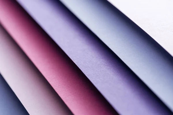 Primer plano de hojas de papel azul, blanco, borgoña, rosa y púrpura - foto de stock