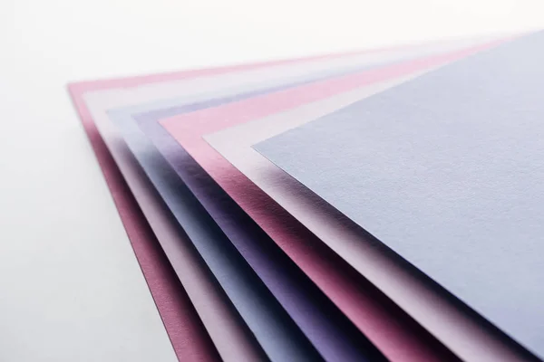 Folhas de papel azul, branco, rosa e roxo sobre fundo branco — Fotografia de Stock