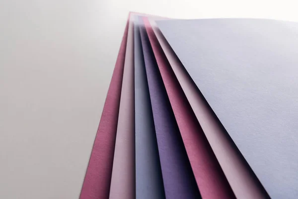 Hojas de papel en blanco azul, blanco, rosa y púrpura sobre fondo blanco - foto de stock
