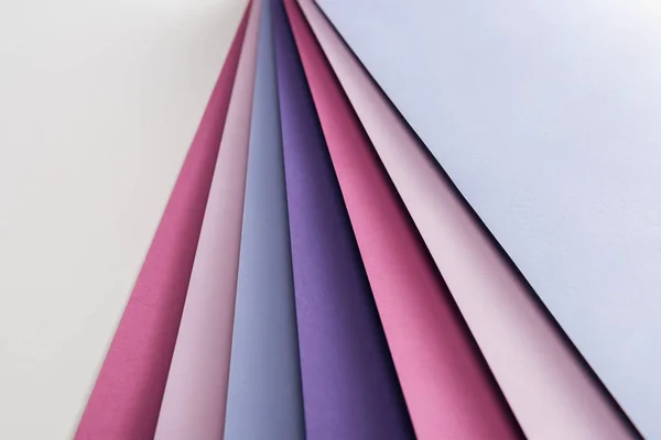 Fogli di carta blu, bianchi, rosa e viola su sfondo bianco — Foto stock