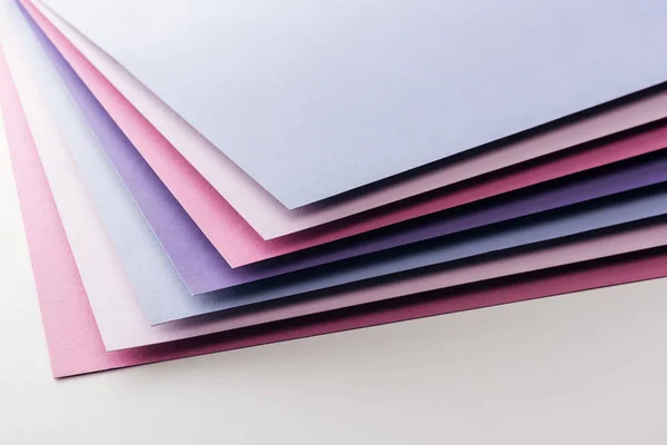 Fogli di carta blu, bianchi, rosa e viola vuoti su sfondo bianco — Foto stock