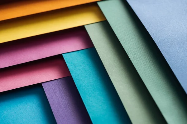 Бургундский, синий, оранжевый, зеленый, желтый, розовый и фиолетовый листы бумаги — стоковое фото
