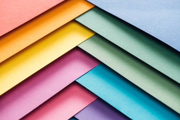 Hojas de papel azul, naranja, verde, borgoña, amarillo, rosa y púrpura con espacio para copias - foto de stock