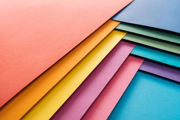 Flat lay of blue, orange, green, burgundy, yellow, pink and purple sheets of paper — Stock Photo