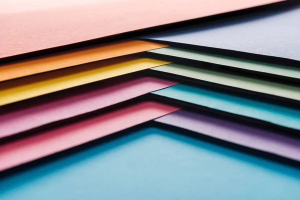 Blank and bright blue, orange, green, yellow, pink and purple sheets of paper on blue background — Stock Photo