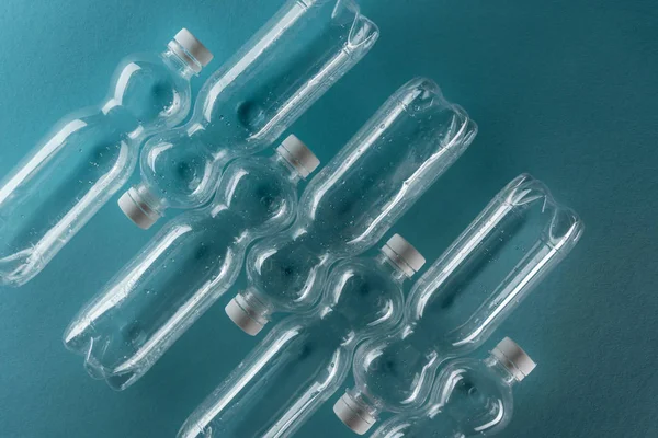 Top view of empty plastic bottles on turquoise background — Stock Photo