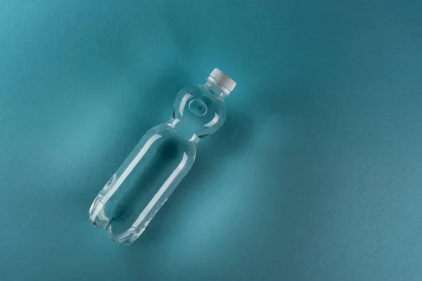 Top view of plastic water bottle on turquoise background with copy space — Stock Photo