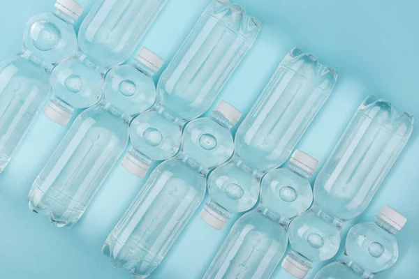Top view of arranged plastic watter bottles on turquoise background — Stock Photo