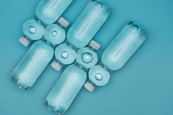 Top view of plastic water bottles isolated on turquoise — Stock Photo