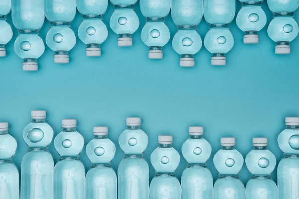 Vista dall'alto di bottiglie d'acqua disposte di plastica isolate su turchese — Foto stock