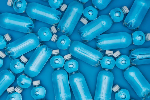 Top view of plastic water bottles isolated on blue — Stock Photo