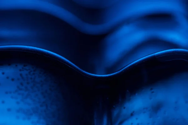 Close up de garrafa de água de plástico com bolhas no fundo azul — Fotografia de Stock