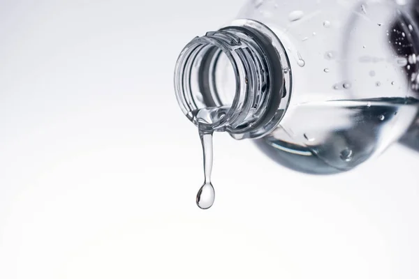 Water dripping from plastic bottle isolated on white with copy space — Stock Photo