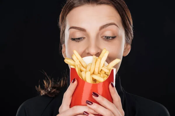 Frau sieht Pommes isoliert auf schwarz — Stockfoto